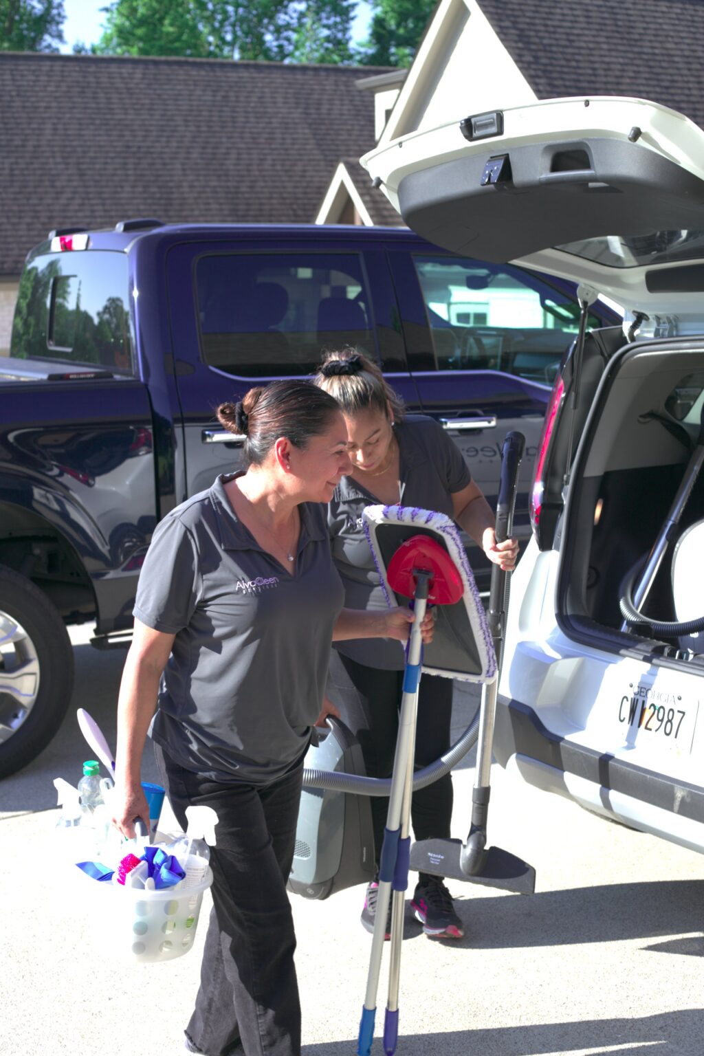 AlvaCleen team loading cleaning gear into the company vehicle at a client's home in Metro Atlanta, preparing for eco-friendly residential cleaning.