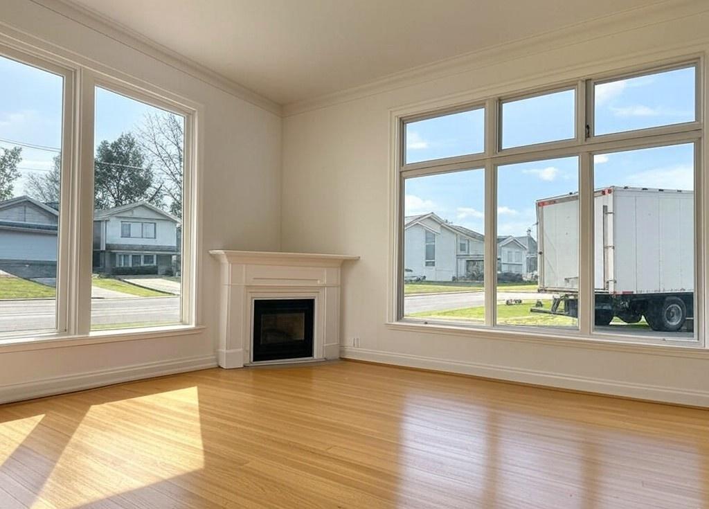 Empty clean living room and large window with a fireplace and a moving truck in the background. Moving Cleaning Service