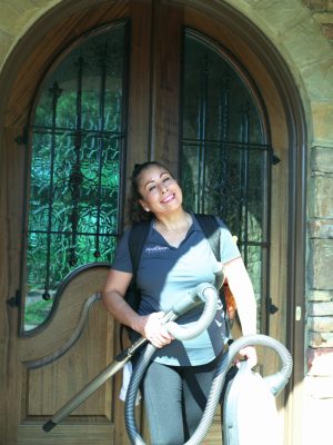 AlvaCleen team member smiling holding a vacuum outside of a client's home in Metro Atlanta